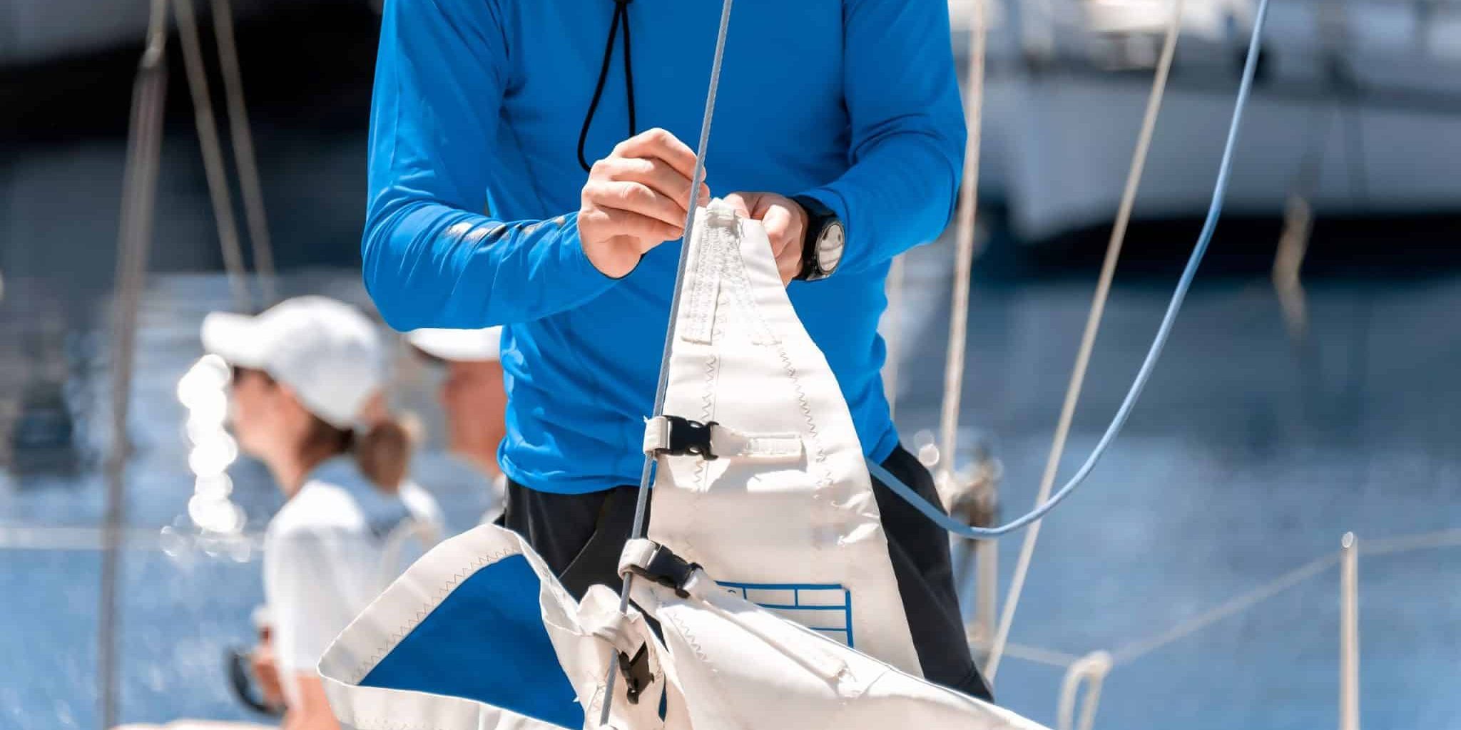 Midsection of a yachtsman checking sail before competition